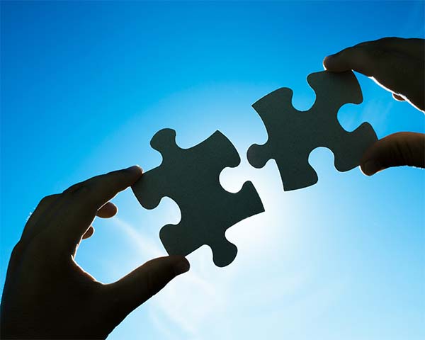 hands holding puzzle pieces together