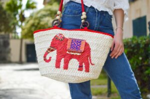 A decorated reusable grocery bag with a red elephant on it.