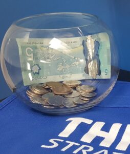 A jar full of money from when people forget their reusable bags.