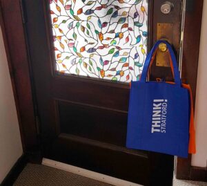 Several reusable Think! Stratford bags hanging on front door